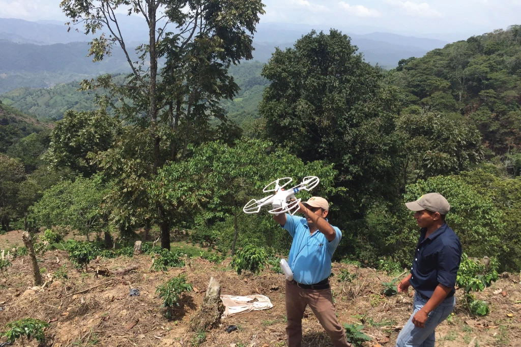 A man launching a drone to survey a landscape
