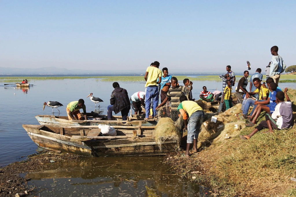 Young rural fisherman attend to nets and their boat