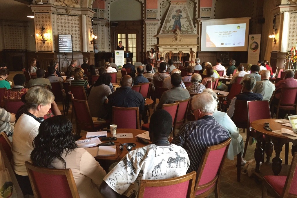 Caux Dialogue participants site around round tables and listen to the speaker Caux Dialogue participants site around round tables and listen to the speaker