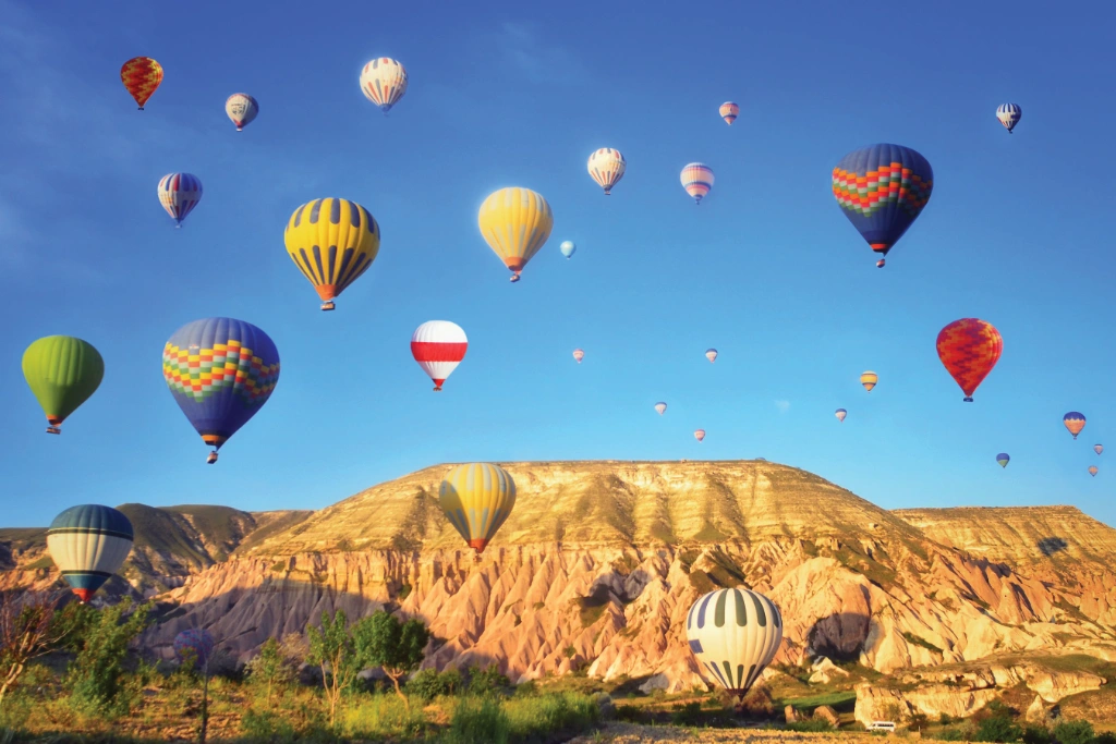 Hot air ballons against a blue sky and Turkish landscape of eroded hills Hot air ballons against a blue sky and Turkish landscape of eroded hills
