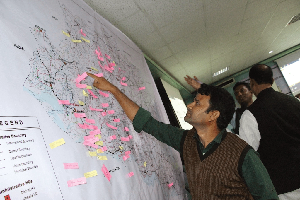 A man points to a location on a map of India A man points to a location on a map of India