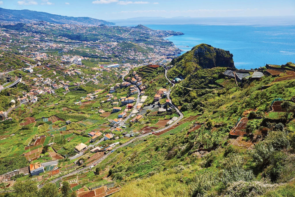 Terraced landscape overlooking farmland, village and ocean in France