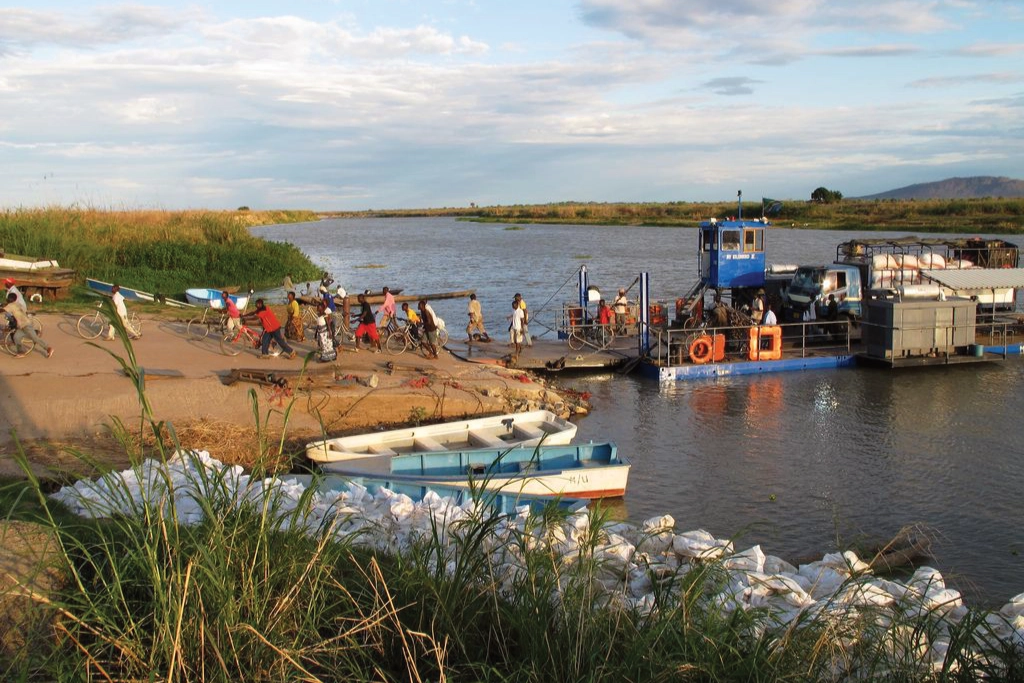 Men and women disembark from a ferry, many with their bicycles