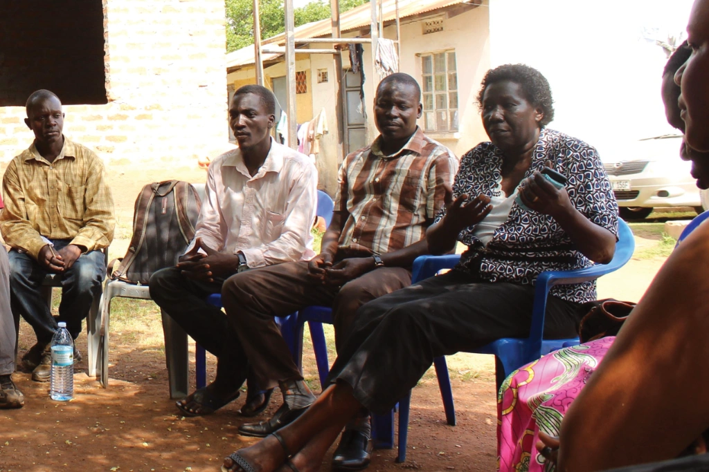 Newly trained farms sit on chair outside during a focus group held in the Lira District of Northern Uganda