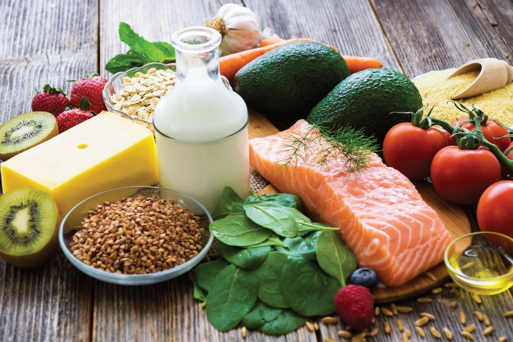 Selection of healthy wholefoods - fruit, vegetables, dairy, grains, oils